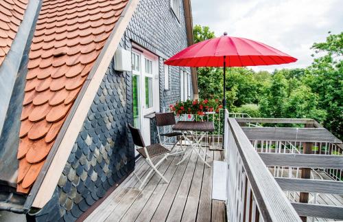 苏尔Appartement Stadtpartie的一个带桌子和红色遮阳伞的庭院