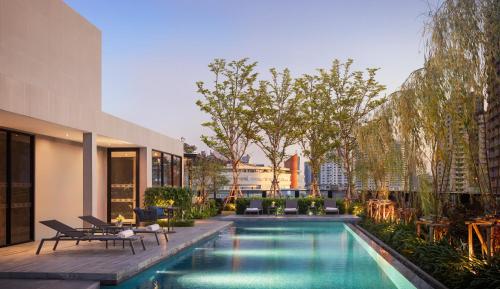 曼谷曼谷素坤逸莎玛 Luxe 服务式公寓的一座建筑物中央的游泳池