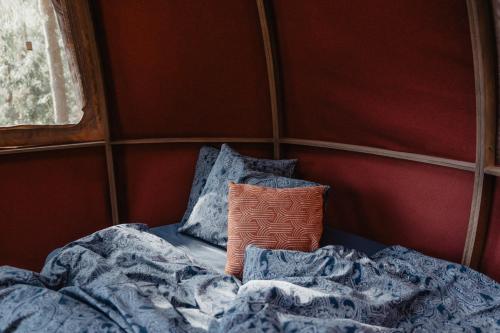 BūtingėNature calls - tree tents的客房内的一张带枕头和毯子的床