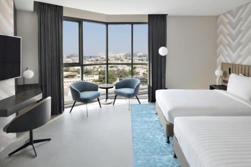 迪拜Courtyard by Marriott World Trade Centre, Dubai的一间酒店客房,设有两张床和电视