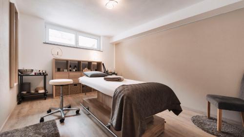 贝旺Alpenflair的一间卧室配有一张床、一张桌子和一把椅子