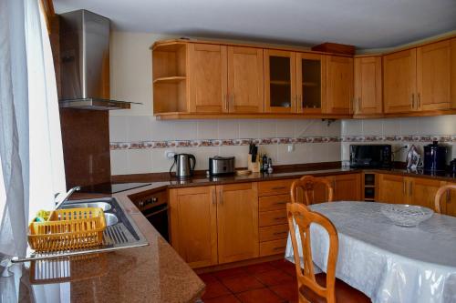 圣维森特Casa do Cantinho do Muro的厨房配有木制橱柜和一张桌子。