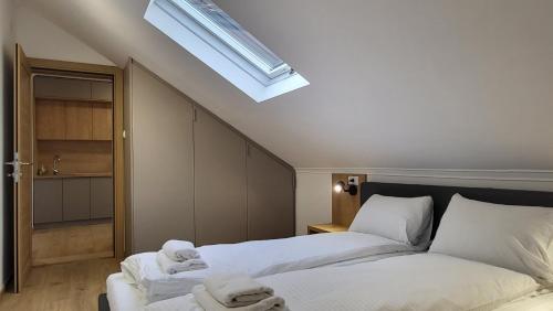 查查克Apartments Spring的一间卧室配有两张带白色床单的床和天窗。