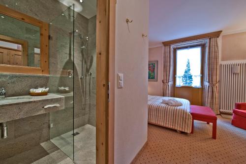 锡尔斯玛丽亚马尔基纳苏培利尔公园酒店的带淋浴和盥洗盆的浴室以及1张床。