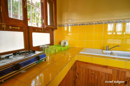 菲亚纳兰楚阿An-tsaha Chambre d'hôtes的黄色的厨房设有炉灶和水槽