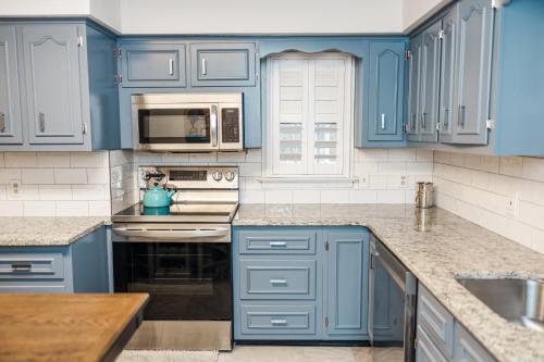 纽霍普Cowry Acres - The First House Villa w Hot Tub的蓝色的厨房配有白色家电和蓝色橱柜