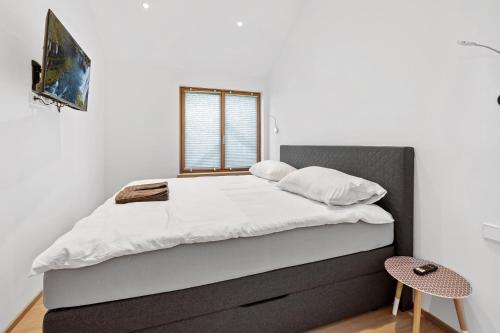 韦因道旁格兰茨Luxus Chalet Max的卧室配有一张带白色床单的大床和窗户。