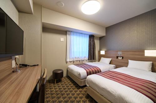 大阪难波原町WBF酒店的酒店客房设有两张床和一台平面电视。