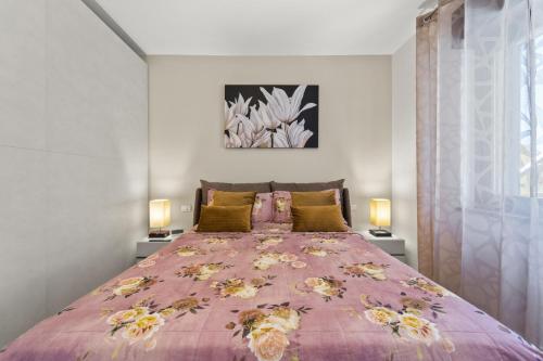 卡洛福泰Ca' Alessandra的一间卧室配有一张带两盏灯的大型粉红色床。