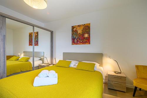 瓦讷L'Audacieux - Appt neuf avec vue sur les toits的一间卧室配有两张黄色的床和镜子