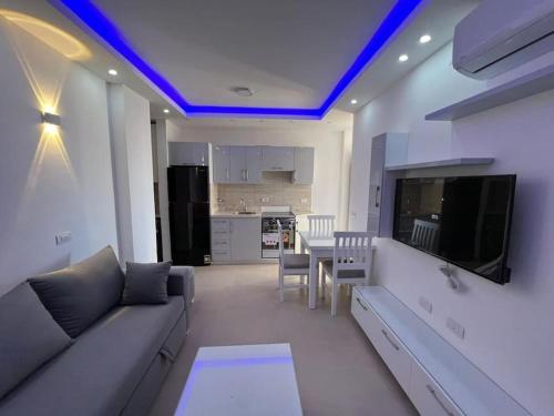 沙姆沙伊赫Beautiful 1 Bedroom apartment in el Montazah的带沙发和电视的客厅以及厨房。