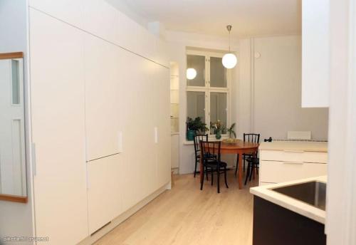 赫尔辛基Corner apartment的厨房配有白色橱柜和桌椅