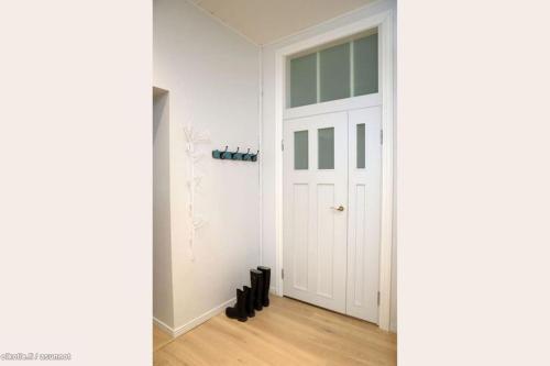 赫尔辛基Corner apartment的走廊上设有白色门和黑色鞋