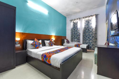 斋浦尔FabExpress Green Vista的一间卧室设有一张床和蓝色的墙壁