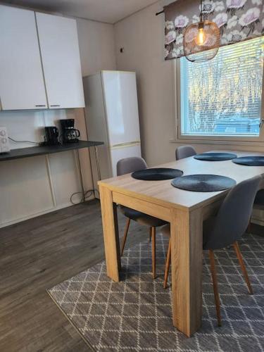 Gáiju Apartment的带木桌和椅子的厨房以及带窗户的厨房。
