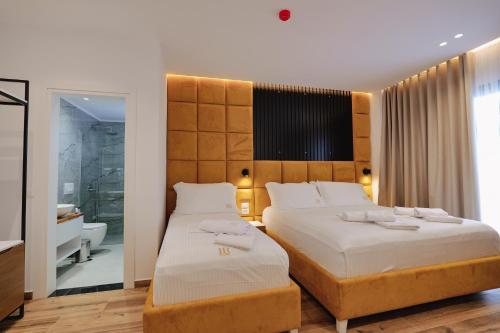 卡萨米尔HOTEL RENATO的一间带两张床和大床头的卧室