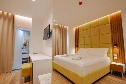 卡萨米尔HOTEL RENATO的一间卧室配有一张带黄色床头板的大床
