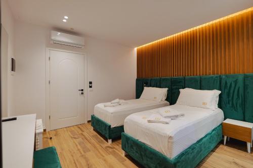 卡萨米尔HOTEL RENATO的一间卧室设有两张床和绿色床头板