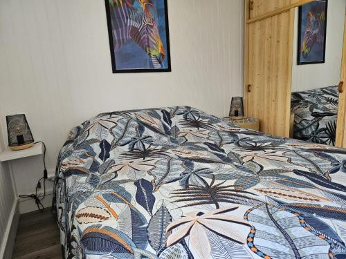 梅尔维尔弗朗瑟维尔普拉格Charmant chalet 200 m de la mer的一间卧室配有一张带五颜六色棉被的床