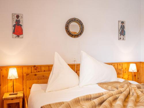 楚奥茨Apartment Chesa Clüs 6 by Interhome的一间卧室配有一张带白色床单和镜子的床