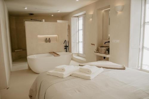 贝赫尔-德拉弗龙特拉EntreArcos Casa Eco-Boutique的带浴缸和床的白色浴室