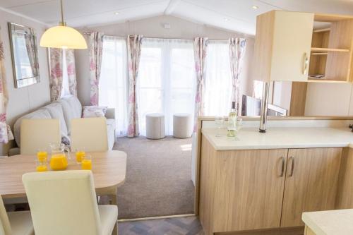 巴茅思巴茅斯湾假日公园酒店的厨房以及带桌椅的起居室。