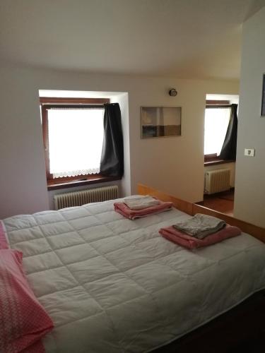 加尔达湖滨APP Angela - Ardaro 2的卧室配有一张白色大床和两个窗户