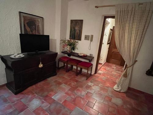 蒙泰斯库达伊奥Residence La Villa的带电视的客厅和瓷砖地板。