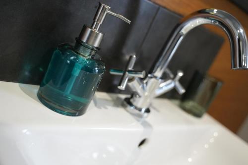 梅瑟蒂德菲尔Charming 1-Bed & balcony Flat in Merthyr Tydfil的浴室水槽上放着一瓶蓝色肥皂