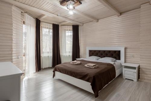 布克维Villa Morishka & SPA的一间卧室配有一张大床和两条毛巾
