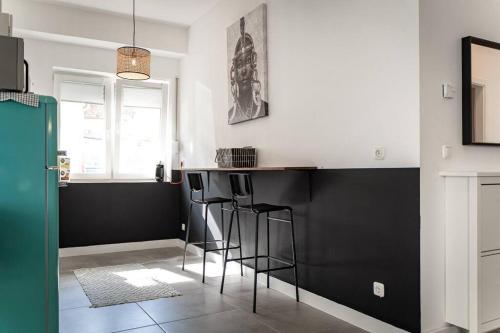 奥芬巴赫Moderne Wohnung im Herzen Offenbachs的厨房拥有黑白墙壁和酒吧凳子