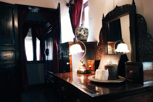 清迈提延那茹殖民饭店的一间设有一张桌子、两盏灯和一面镜子的房间