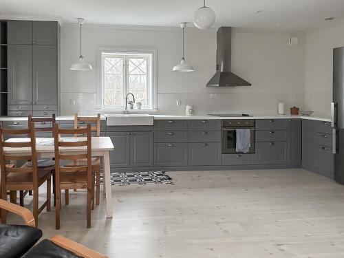 恩雪平Vallby Cottage的厨房配有灰色橱柜和桌椅