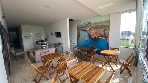 卡宁德圣弗朗西斯科Pousada Boa Vista的一间设有桌椅的房间和墙上的绘画