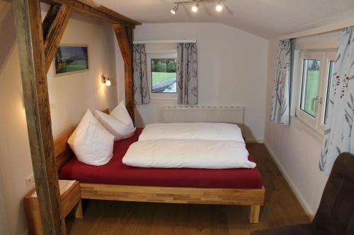 拉姆绍达赫斯坦Burglehnerhof的一张位于小房间的床,配有红色床垫