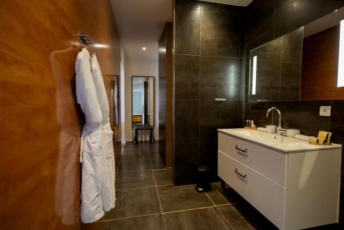 维琪奥港SWIM LODGE HOTEL Piscine privée ou Jacuzzi privé的一间带水槽和白色浴袍的浴室
