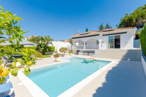 马贝拉Modern villa with Heated Pool & BBQ Next to the Beach的一座房子后院的游泳池