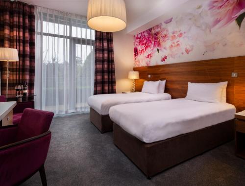 Moyvally莫伊谷高尔夫度假酒店的酒店客房,配有两张床和椅子