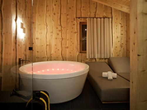 科尔蒂纳丹佩佐Dolomiti Lodge Alverà的一间带浴缸的浴室和一张长凳