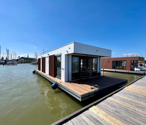 蒙尼肯丹Luxury Houseboat Liberdade with sauna and dinghy的水面上的小房子
