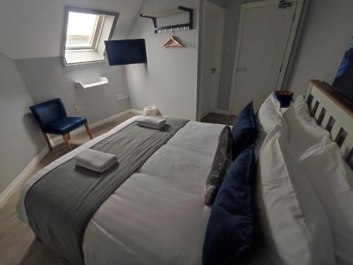 基拉尼Kingdom Lodge的一间卧室配有一张大床和蓝色椅子