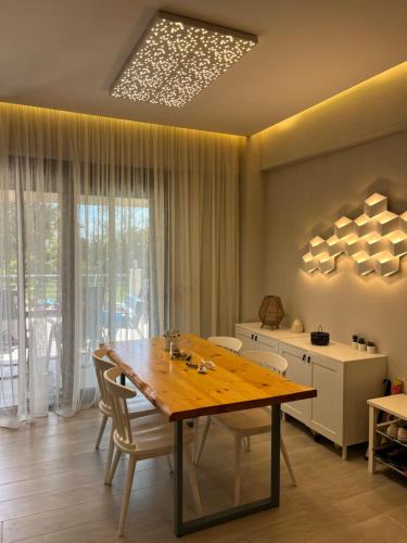 尼基季Nikiti Heart Luxury Villa的一间带木桌和椅子的用餐室