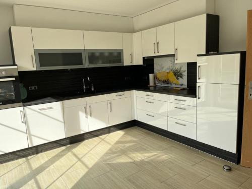 施内沃丁根Marina, Ferienwohnung的厨房配有白色橱柜和黑色台面