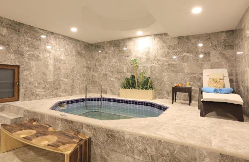 克孜勒贾哈马姆Cam Thermal Resort Hotel & Spa的一间大浴室,在房间内设有一个游泳池