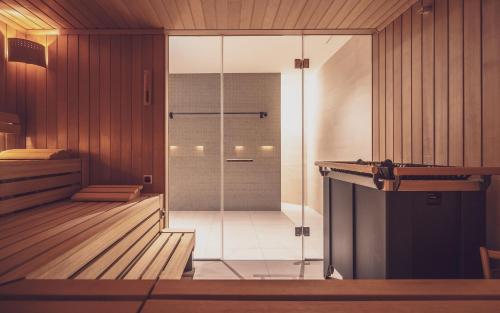 达沃斯Parsenn Resort的木墙客房内的玻璃淋浴间