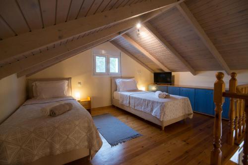 沃伊多基利亚Petrochori Beach House的阁楼卧室配有两张床和电视