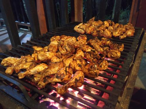 代尼耶耶Rainforest View Hostal And Rainforest Tours的烤架上的一串鸡肉烹饪