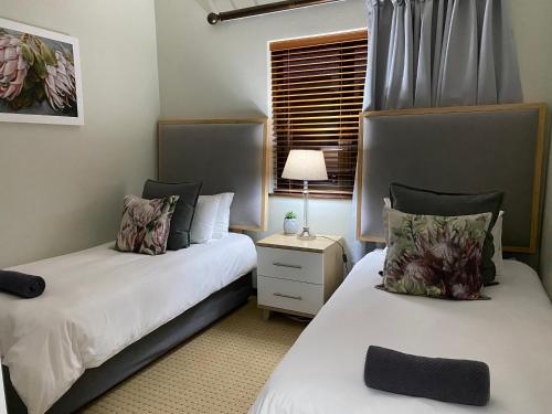 莫塞尔湾Rosebud 4 Beacon Point的一间卧室设有两张床、一盏灯和一扇窗户。