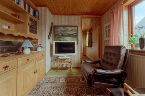 3-Bedroom Home in Eiði的客厅配有椅子和电视