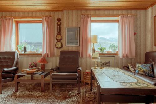 3-Bedroom Home in Eiði的带沙发和桌子的客厅以及2扇窗户。